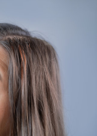 Hair extensions in beauty salon attention to each strand and capsule professional hairstylist at workの写真素材