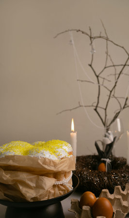 Festive Easter table with cake in white icing, painted eggs, candles, and a neat twig nest...