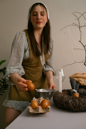 Warm Easter preparation moment, arranging treats and decorating the table, smiling with quiet joy at...