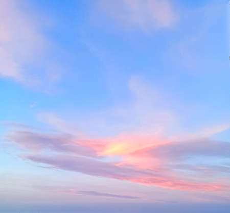 Blue sky with pink large and small clouds during sunset. Can be used for background, there is room for copy space.の写真素材