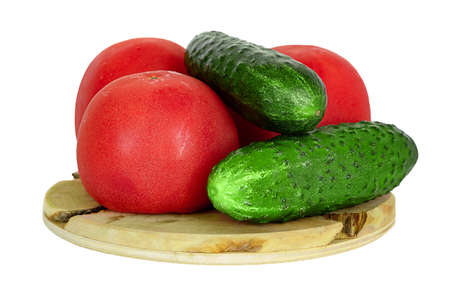 Fresh green cucumbers and tomatoes isolated on a white background on a wooden stand. For the design.の写真素材