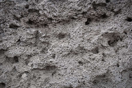 The texture of an old stone wall with small holes. Background.の写真素材