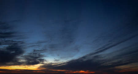 defocused background of orange sunset in dark blue skyの写真素材