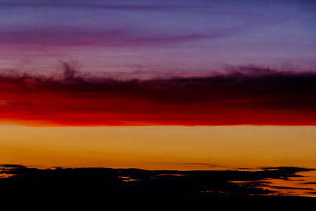 Bright dramatic sky with red and orange clouds at sunset.の写真素材