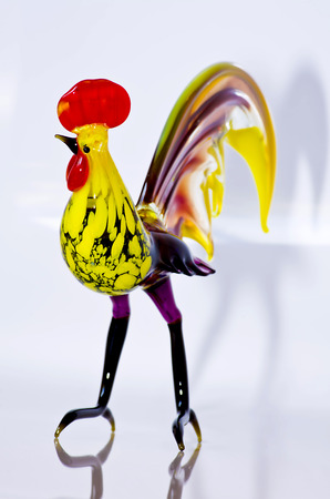 Glass rooster on a white background. Figurine handmade made of colored glassの写真素材