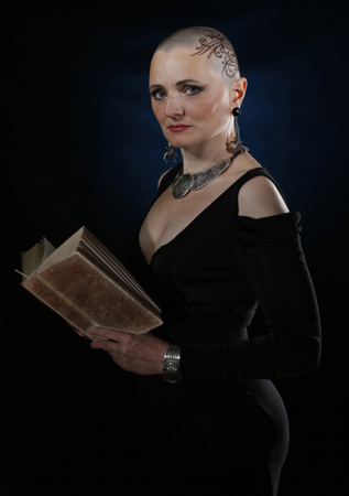 Bald woman with a book in her handsの写真素材