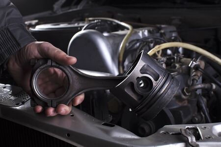 Car engine maintenance. Engine piston system repair. Hands with a mechanic with a piston and...