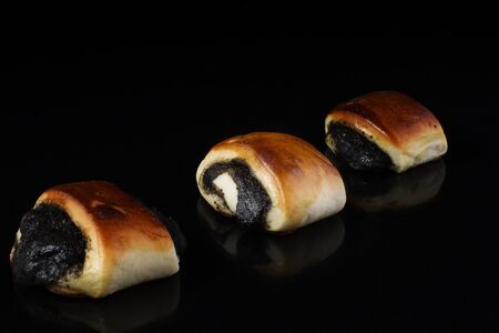 Buns with poppy seeds on a black backgroundの写真素材