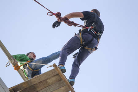 Belarus, Gomel, May 01, 2017.Jumping with a rope.A man pushes another man from the bridge. Engage in extreme sports.のeditorial素材