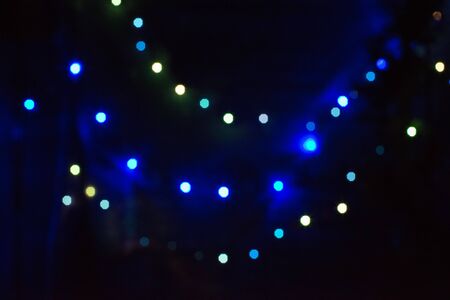 Festive bokeh New Year's lights. Blue yellow, green, multicolored. Small bright spots