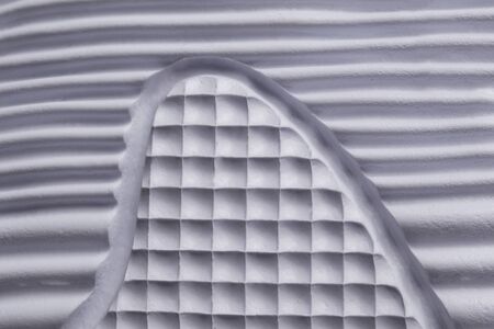 Fragment of a rubber white sole of a sneaker. Bottom of sports shoes