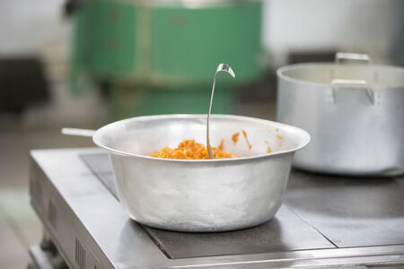 Metal bowl with food in the industrial kitchen