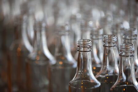 Glassworks. Glass industry. Many glass bottles on a factory conveyor.の写真素材