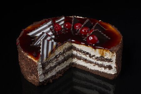 A piece of chocolate cake with white cream on a black backgroundの写真素材