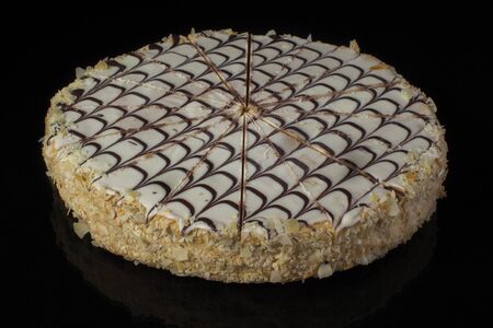 Cake decorated with chocolate mesh and butter cream on a dark background closeup
