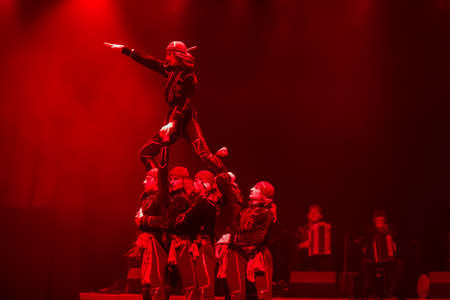 Belarus, Gomel, February 27, 2018. Concert hall. Speech of the national Georgian ballet Sukhishvili.Georgian dancers performing red-lighted dance on stageのeditorial素材