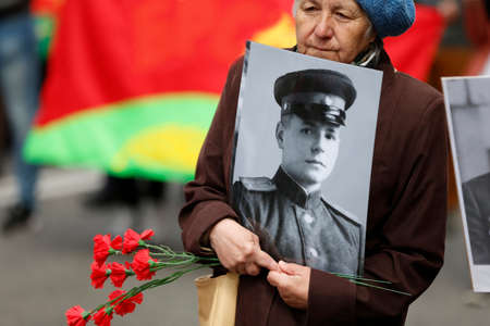 Belarus, Gomel, May 9, 2017, the Victory Day celebration.A woman carries a photograph of a father's...