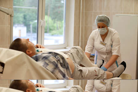 Belarus, the city of Gomel.City burn hospital,June 1, 2017.A nurse unidentified patient bandages a sore legのeditorial素材