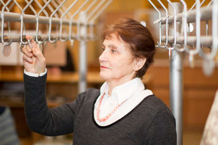 Belarus The city of Goomel, November 20, 2017. The employee issues a number. Work cloakroom. Take out your coat.のeditorial素材