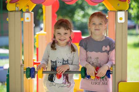 Belarus, the city of Gomil, April 26, 2019. Kindergarten on the street.Two funny girls from kindergarten on a summer walk. Six year old children play on the playground.のeditorial素材