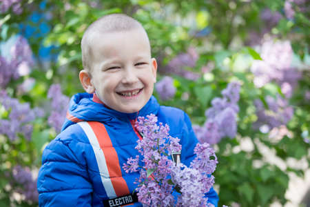 Belarus, the city of Gomel, May 11, 2019. Open day in kindergarten.A child in a lilac. Laughing boy with a bouquet of spring flowers.のeditorial素材
