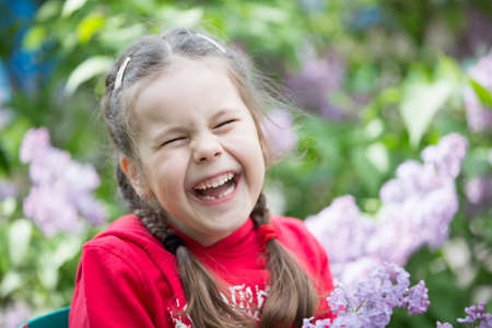 Belarus, the city of Gomel, May 11, 2019. Open day in kindergarten.A child in a lilac. Laughing girl preschooler with a bouquet of spring flowers.のeditorial素材