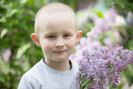 Belarus, the city of Gomel, May 11, 2019. Open day in kindergarten.A child in a lilac. Laughing boy with a bouquet of spring flowers.のeditorial素材