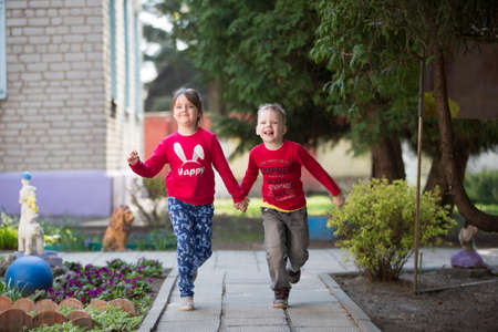 Belarus, the city of Gomil, April 26, 2019. Kindergarten on the street.A boy and a girl from kindergarten for a walk. Happy children in the summer run on the track.のeditorial素材