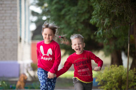 Belarus, the city of Gomil, April 26, 2019. Kindergarten on the street.A boy and a girl from kindergarten for a walk. Happy children in the summer run on the track.のeditorial素材