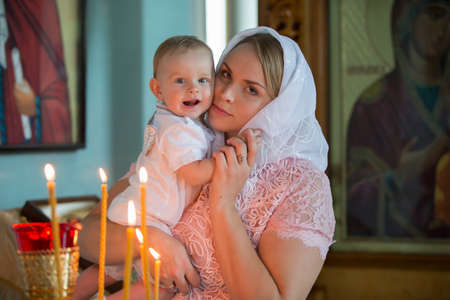 Belarus, the city of Gomil, June 20, 2019. City church.Belarus, the city of Gomil, June 20, 2019. City church. Orthodox baptism. Mother and child in a church by candlelight. Woman with a baby in the temple.のeditorial素材