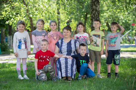Belarus, the city of Gomil, April 26, 2019. Kindergarten on the street.A group of Russian children from kindergarten with a teacher in the summer garden.Kindergarten teacher and childrenのeditorial素材