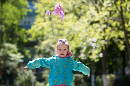 City Gomel, Belarus,April 13, 2017,Kindergarten, senior group, graduation day.Beautiful girl in a spring garden with a lilac in handsのeditorial素材