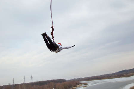 Belarus, Gomel, March 08, 2019. Jumping from the bridge to the rope.Ropejumping.A woman jumps from a...