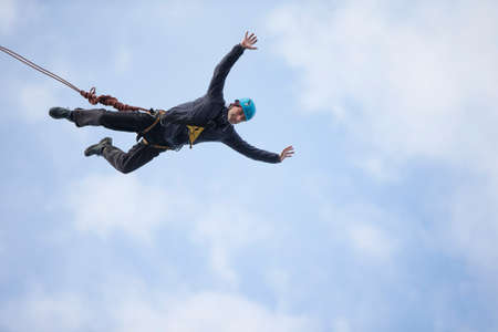 Belarus, Gomel, March 08, 2019. Jumping from the bridge to the rope.Ropejumping.A man jumps from a great height and flies on the rope in the sky. Extreme passionのeditorial素材
