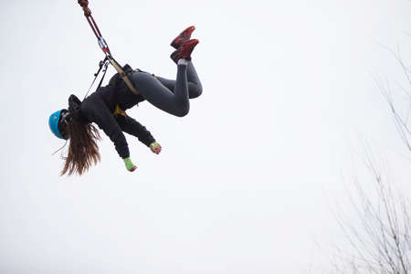 Belarus, Gomel, March 08, 2019. Jumping from the bridge to the rope.The girl hung on the rope while jumping from the bridge.Ropejumpingのeditorial素材