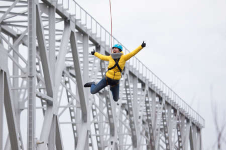 Belarus, Gomel, March 08, 2019. Jumping from the bridge to the rope.Ropejumping.Dangerous hobbies.Brave woman jumping from the bridgeのeditorial素材