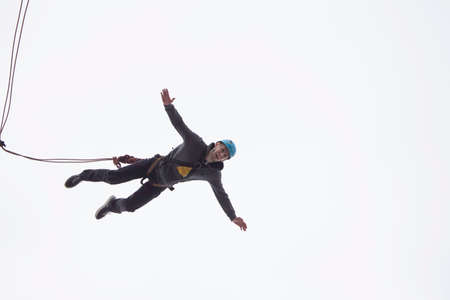 Belarus, Gomel, March 08, 2019. Jumping from the bridge to the rope.Ropejumping.A man jumps from a great height and flies on the rope in the sky. Extreme passionのeditorial素材