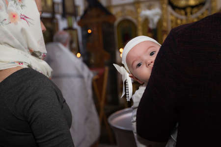 Belarus, Gomel, March 25. 2018. The Prudhkovsky Church.A child at the rite of baptism. Accepting faith. Child in the templeのeditorial素材