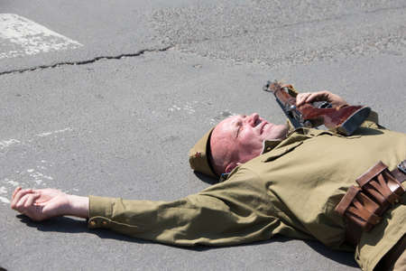 Belarus, Gomel. May 9, 2018. Victory Day. Reconstruction take Reichstag. Russian soldier with a gun lying on the road.Soviet warrior of the second world war with a rifleのeditorial素材