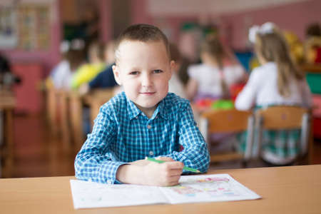 Belarus, the city of Gomil, May 10, 2019. Open day in kindergarten.Child preschooler with book on class background. Boy schoolboy primary school. Portrait of a six year old childのeditorial素材