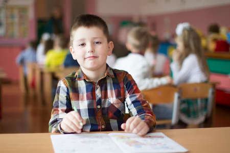 Belarus, the city of Gomil, May 10, 2019. Open day in kindergarten.Child preschooler with book on class background. Boy schoolboy primary school. Portrait of a six year old childのeditorial素材