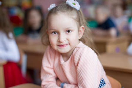 Belarus, the city of Gomil, May 10, 2019. Open day in kindergarten.Child preschooler with book on class background. Girl schoolboy primary school. Portrait of a six year old child. Little student.のeditorial素材