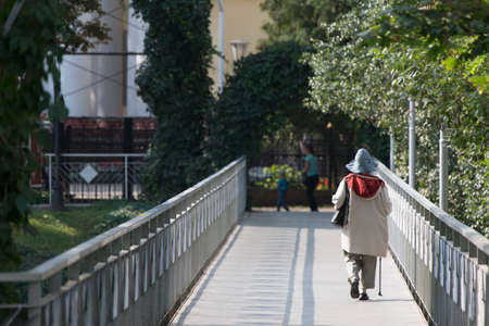 Old woman with a stick goes over the bridgeのeditorial素材