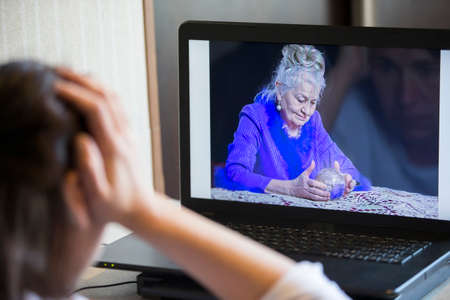 A woman communicates online via a laptop with a fortune teller.のeditorial素材