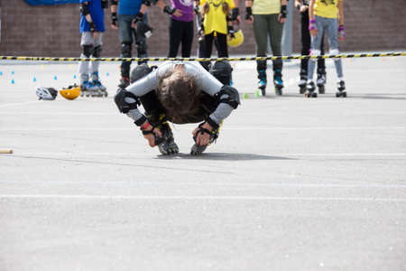 Belarus, Gomel, June 24, 2018. Central Park.Competition in roller sport.An athlete on roller skates rides under the barbellのeditorial素材