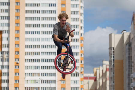 Belarus, Gomel, June 24, 2018. Central park. Extreme cycling.A dangerous trick on a bicycle against the backdrop of the city.Professional cyclist jumped highのeditorial素材