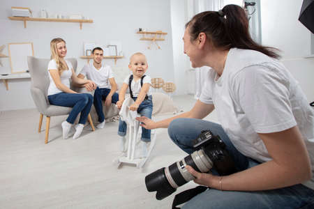 A photographer photographs a family in a photo studio.の写真素材