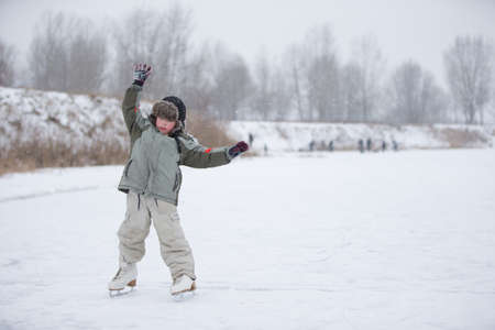 The kid learn to skate. The boy on the lake in winter snowy day on skates. Skating on the lakeの写真素材
