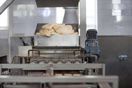 Industrial line of bakery products from yeast dough. Yeast dough in the rear