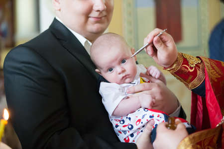 Belarus, Gomel, May 6, 2018. Church of Volotovo. Baptism of a newborn child.Priestess smears a child during Orthodox baptismのeditorial素材